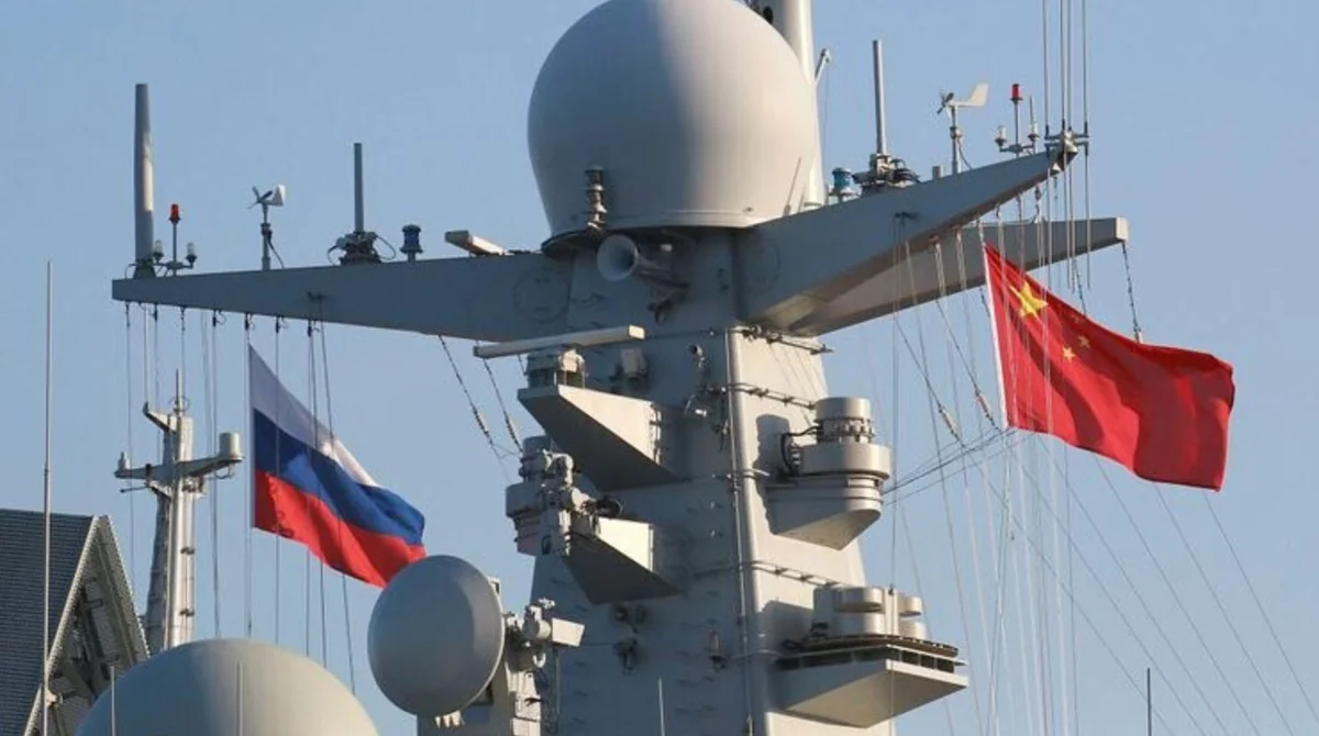 Флаги России и Китая на военном корабле во время морских маневров