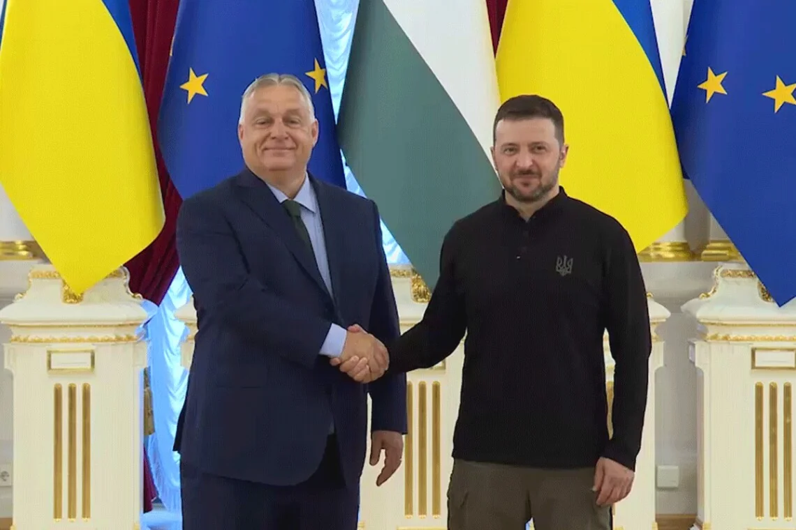 Владимир Зеленский и Петер Мадяр жмут руки на фоне флагов ЕС и Украины